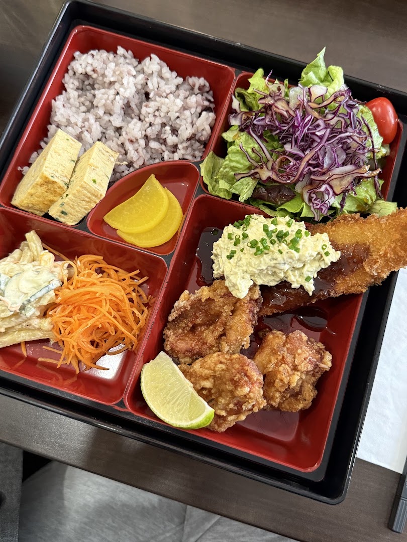 Un bento compartimenté avec riz, fritures, salade et omelette